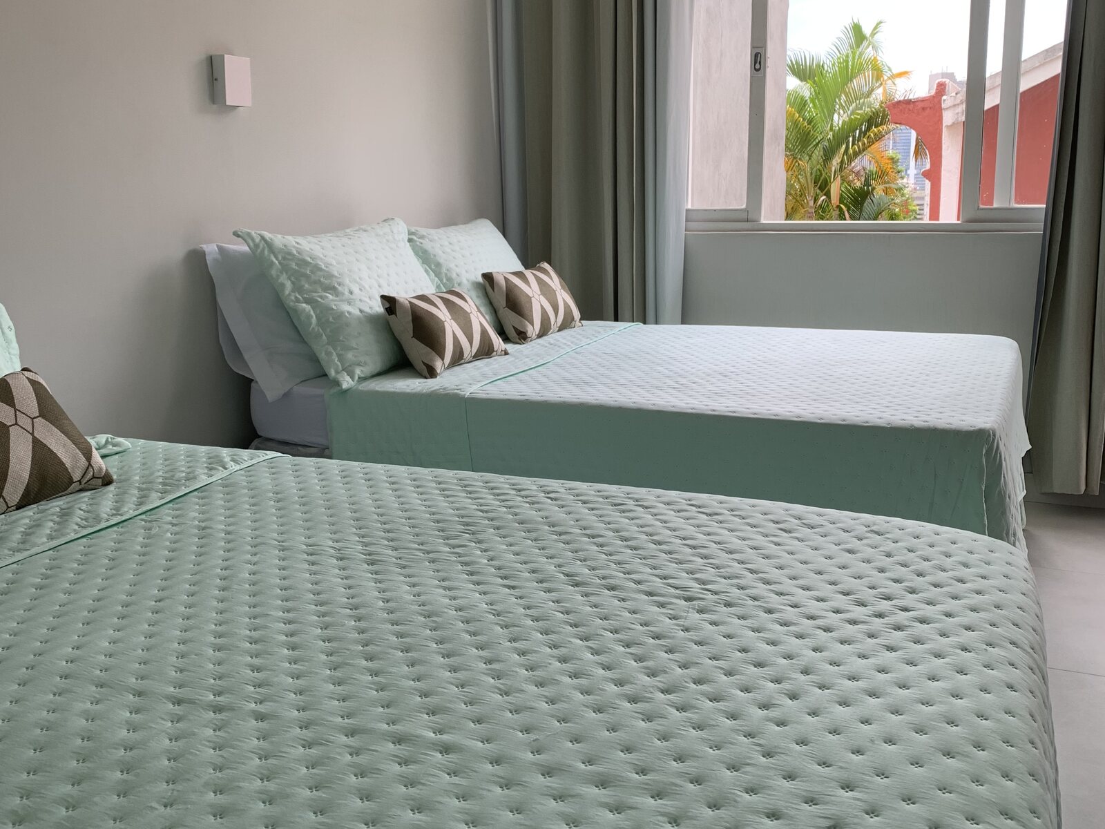 Suíte Beija-flor no anexo da Villa Dourada com cama king, cama de casal e ambiente verde