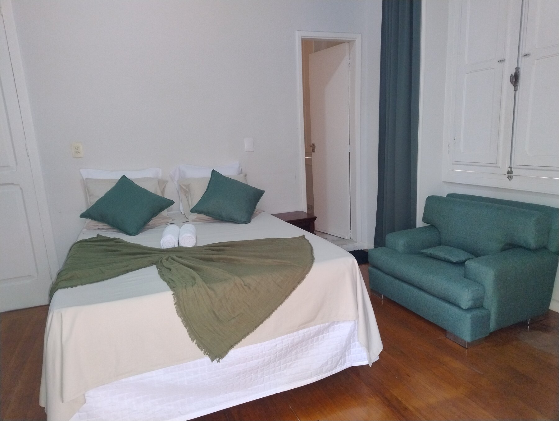 Suíte Sanhaçu da Villa Dourada com cama de casal, sofá e armário